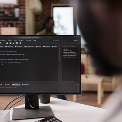 Freelance programmer working remote writing code for software on pc using keyboard debugging algorithm for client. Selective focus on coder computer screen with programming laguage text.